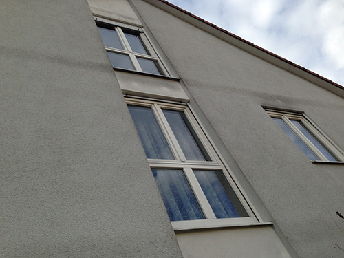 Algenbewuchs an der Fassade aufgrund von Kältebrücken (Deckenstärken zeichnen sich ab).